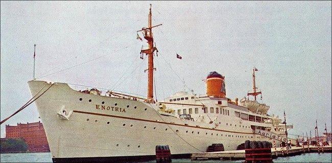 Color photo of the Enotria ship, tied to a dock, three-quarters view, port side